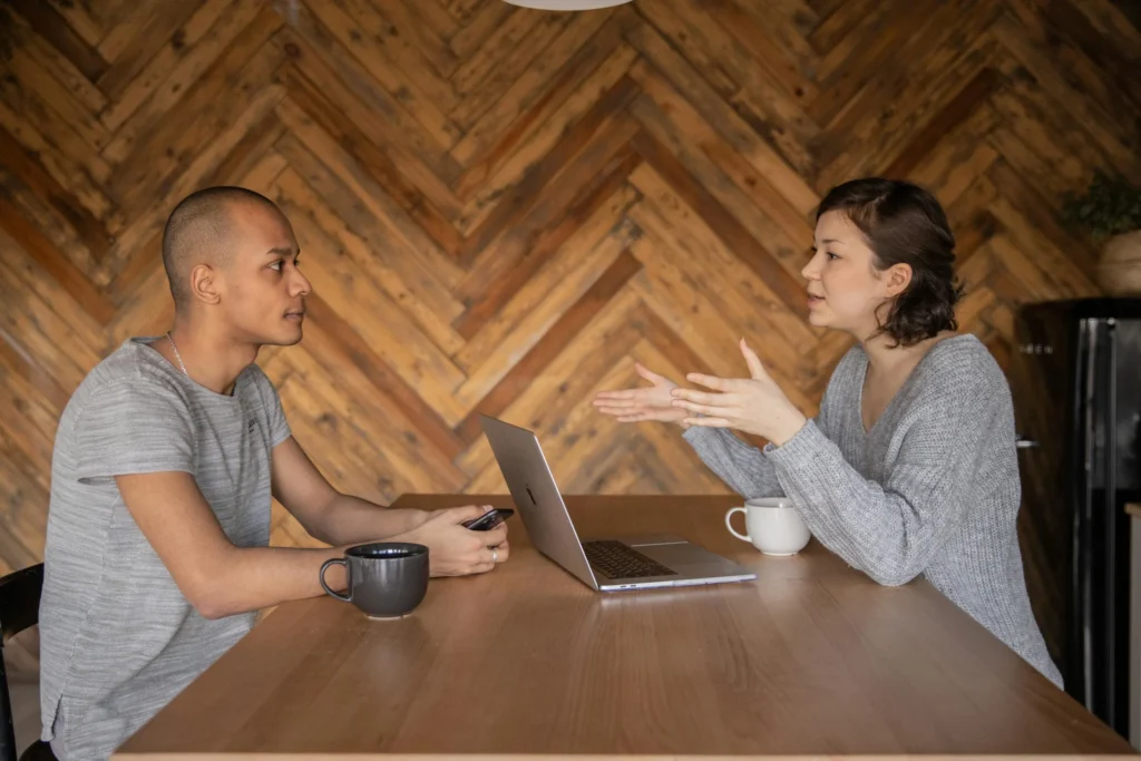 man en vrouw praten aan tafel